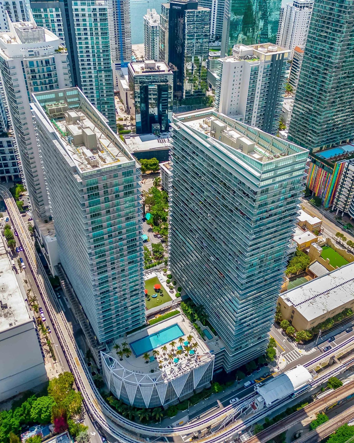 Class A residential towers with landscaped pool decks in a downtown financial district, seen from above