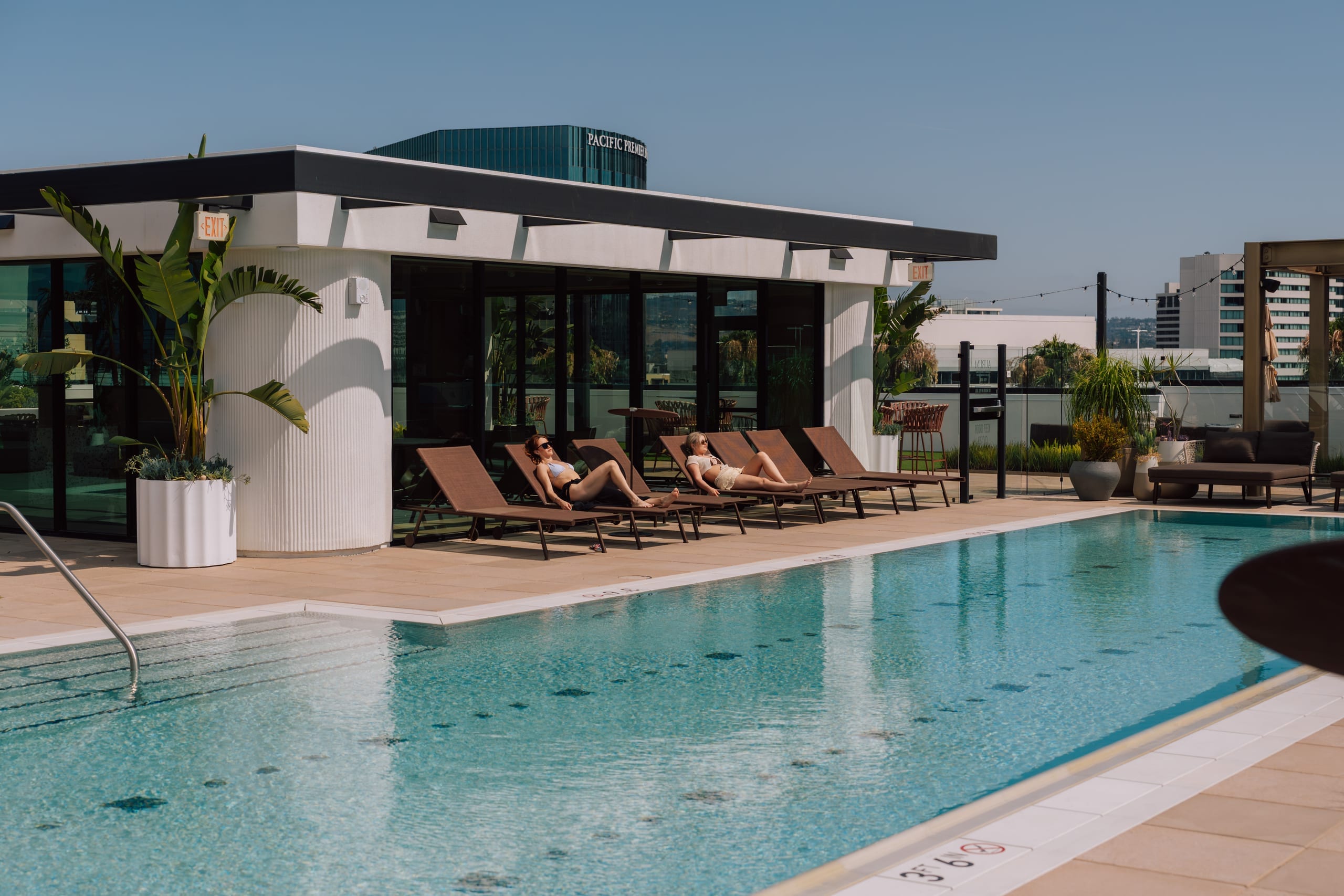 The rooftop pool deck of a World Class building, with residents on loungers and the city beyond