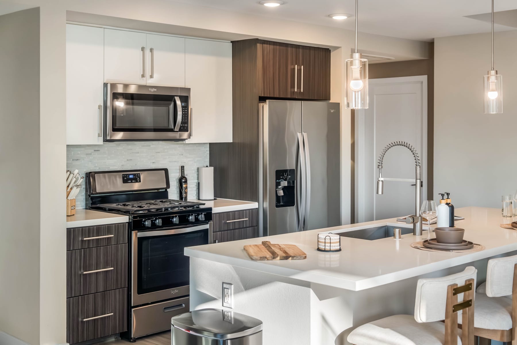 A World Class kitchen with a full-size gas range, microwave and French-door refrigerator, and an island with a sink, knife block and boards