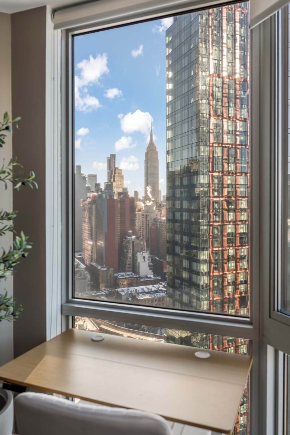 A desk set against the window of a World Class residence, looking out over Midtown to the Empire State Building